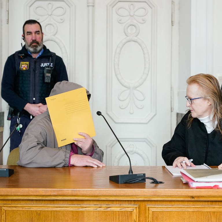 Mann steht vor Gericht und verbirgt sein Gesicht (Foto: picture alliance/dpa | Uwe Anspach)