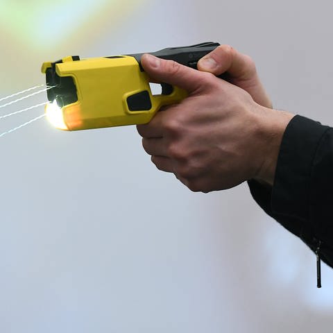 Ein Polizeibeamter demonstriert einen Schuss mit einem Distanzelektroimpulsgerät (DEIG oder auch Taser).  (Foto: dpa Bildfunk, picture alliance/dpa/Revierfoto | Revierfoto)